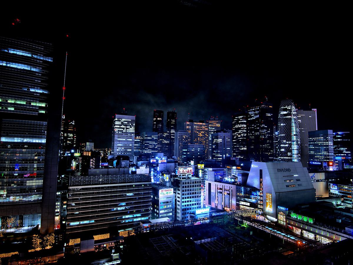 Bright city lights around Shinjuku Station in Tokyo at night
