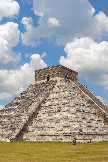 El Castillo pyramid at the ancient Maya city of Chichen Itza under a blue sky