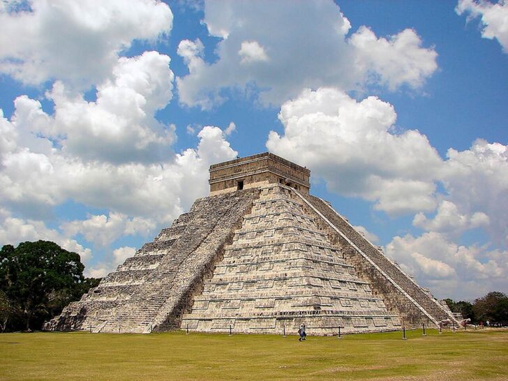 El Castillo pyramid at the ancient Maya city of Chichen Itza under a blue sky