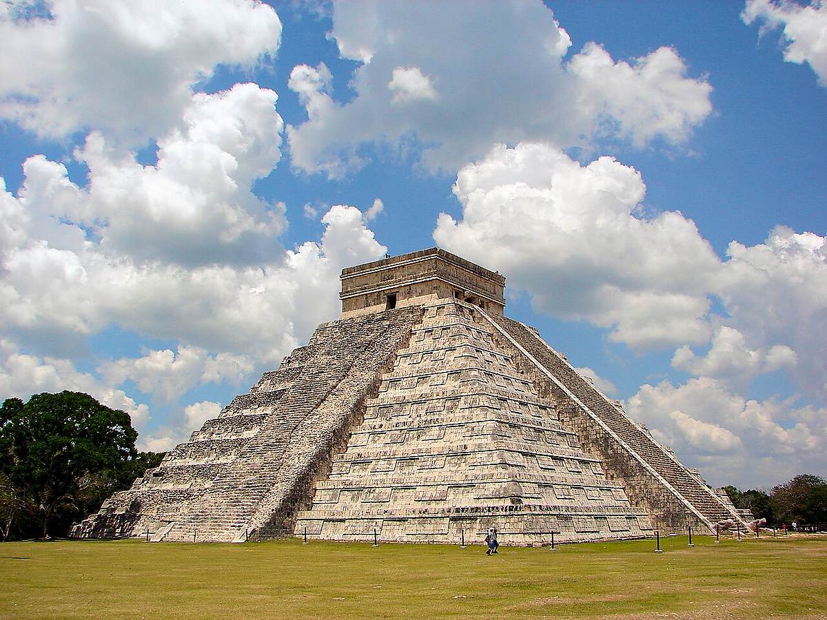 El Castillo pyramid at the ancient Maya city of Chichen Itza under a blue sky