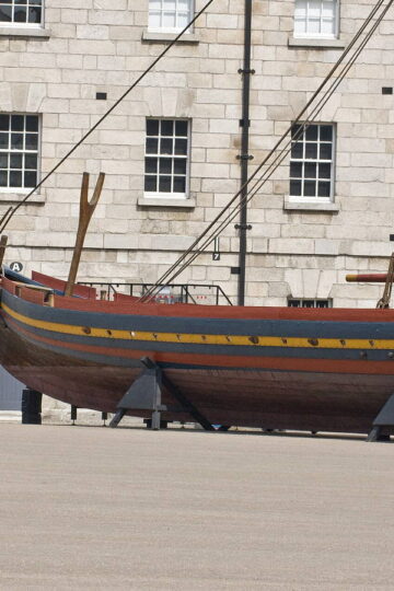 Reconstructed Viking longship Sea Stallion displayed beside a stone building
