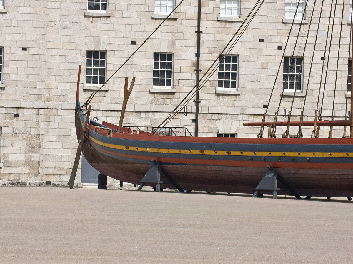 Reconstructed Viking longship Sea Stallion displayed beside a stone building