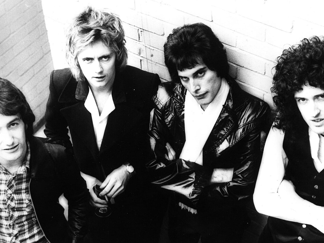 Queen band members in a seated 1977 News of the World press photograph