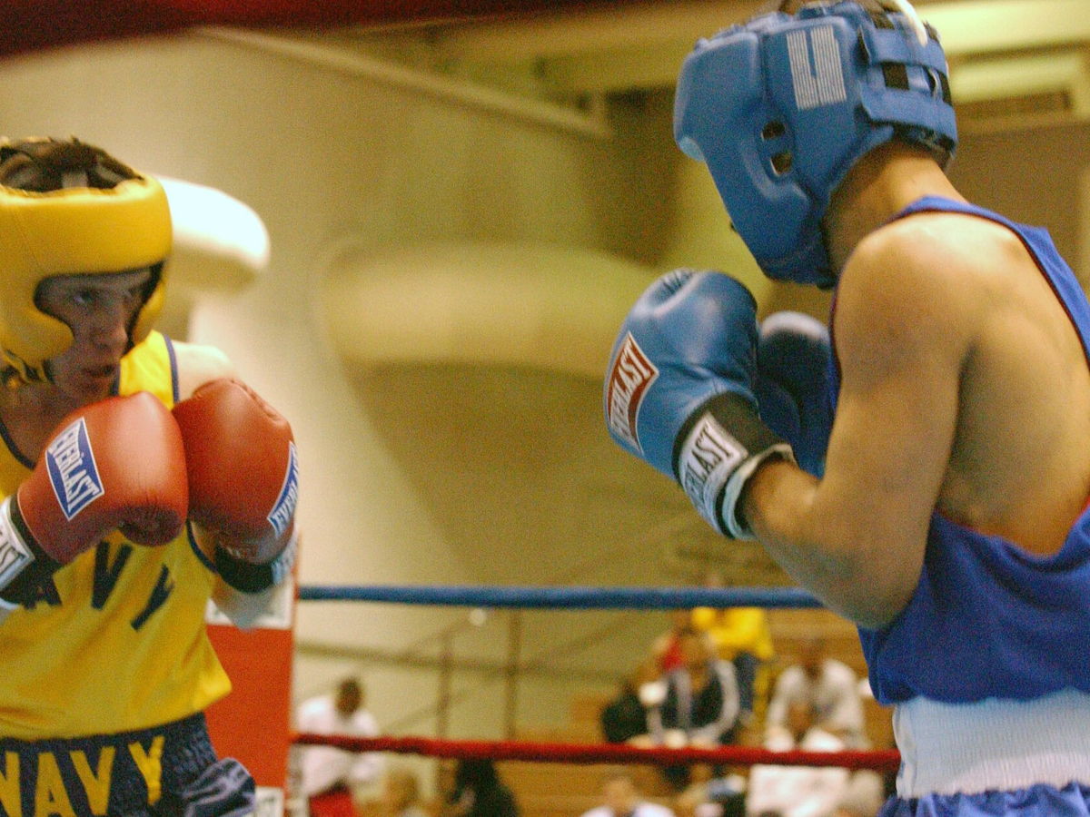 Two U.S. Navy boxers competing in a championship bout inside the ring