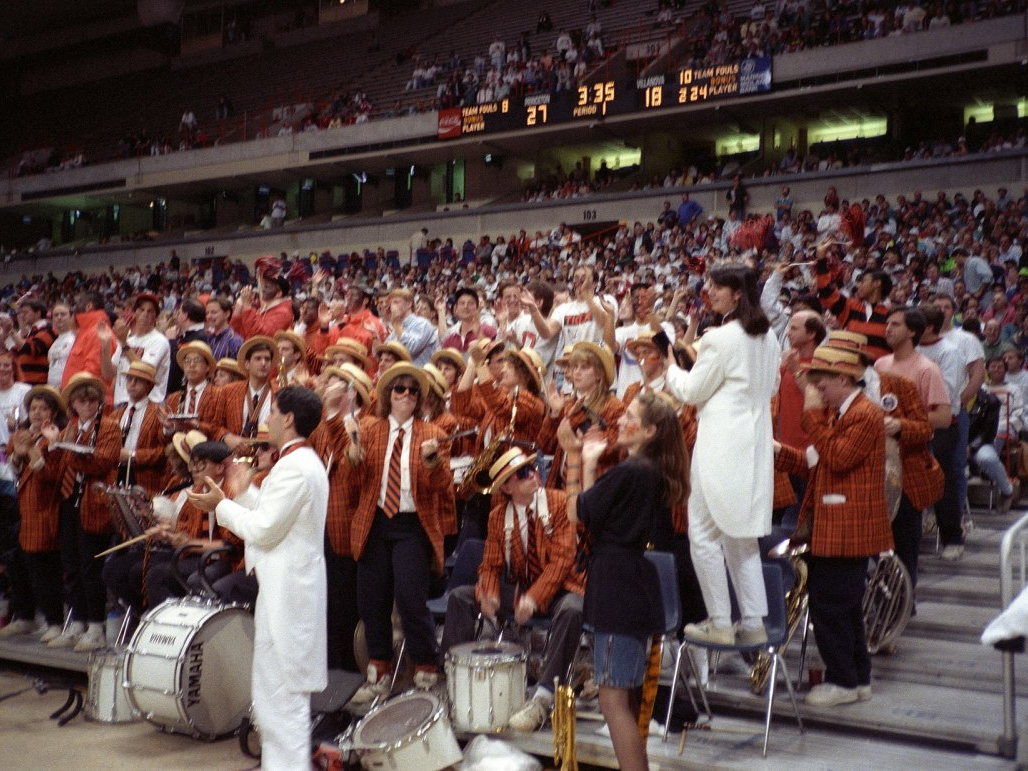College pep band performing in the stands during an NCAA basketball tournament