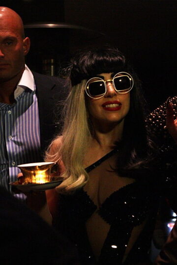 Lady Gaga sings into a microphone during a live performance