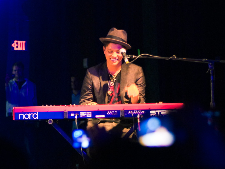 Bruno Mars playing keyboard during a concert in Houston