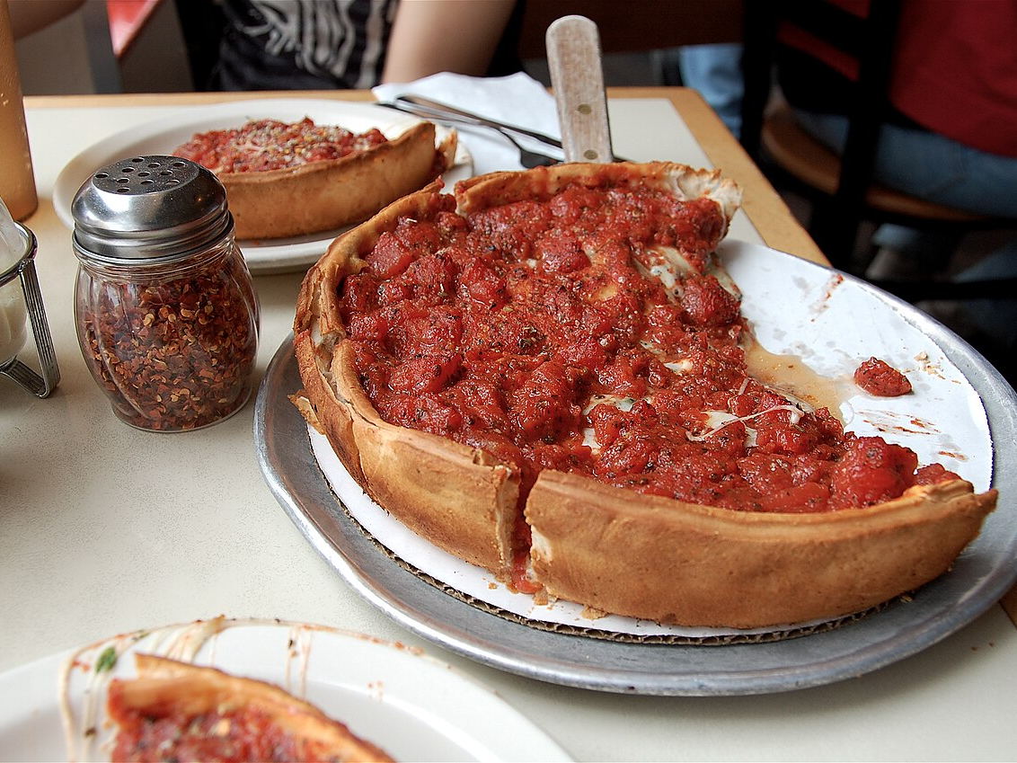 Chicago-style deep-dish pizza with a tall crust and tomato topping