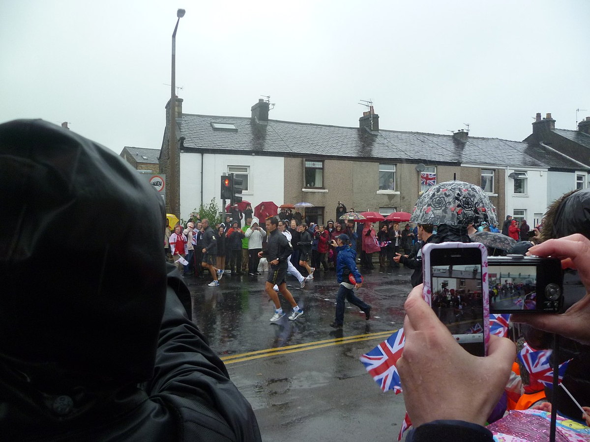 A torchbearer carrying the Olympic flame through Lancaster in 2012