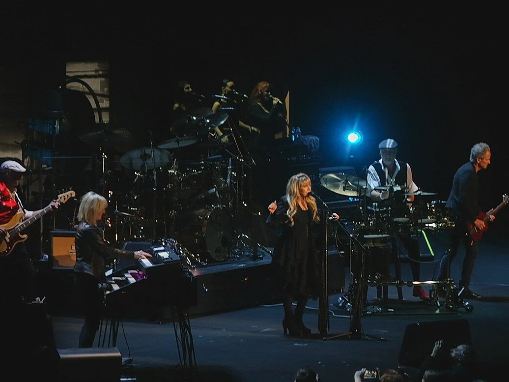 Fleetwood Mac performing under concert lights onstage