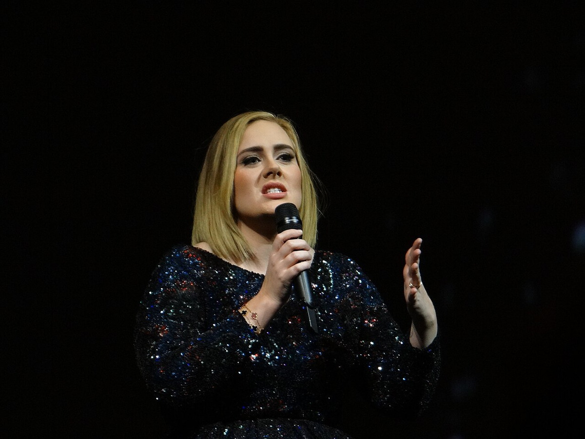 Adele singing into a microphone at a Nashville concert