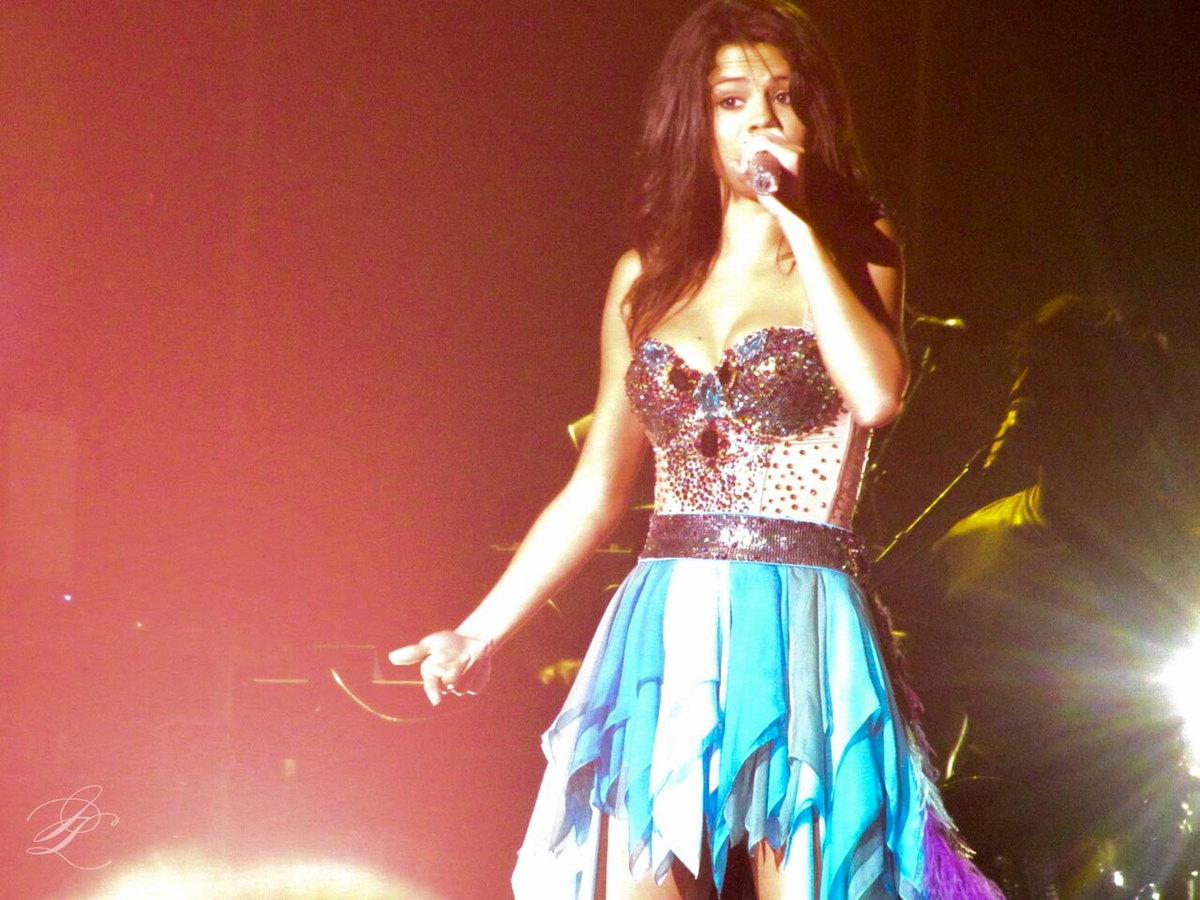 Selena Gomez singing onstage in a sparkling dress