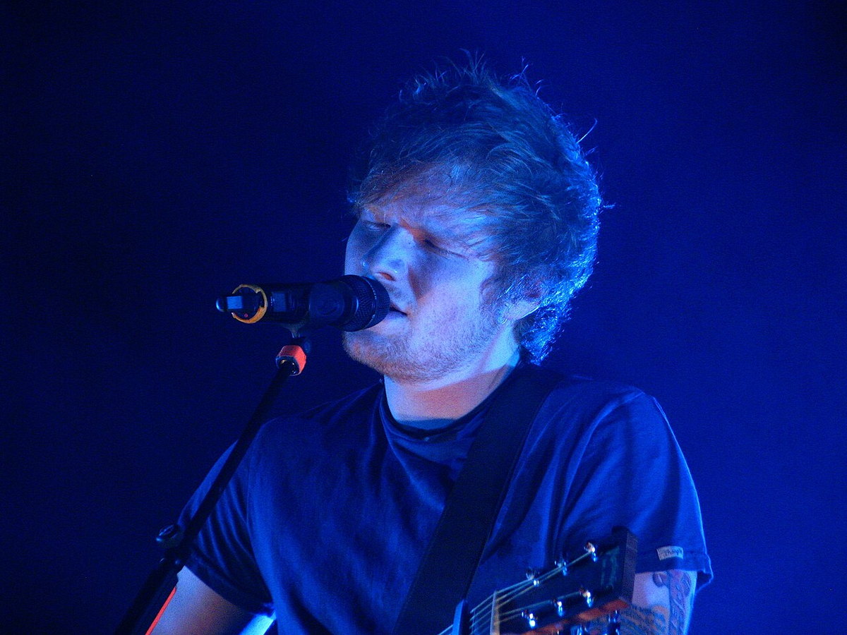 Ed Sheeran performing live onstage with an acoustic guitar
