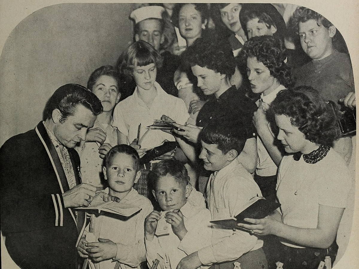 Johnny Cash signing autographs for young fans in 1957