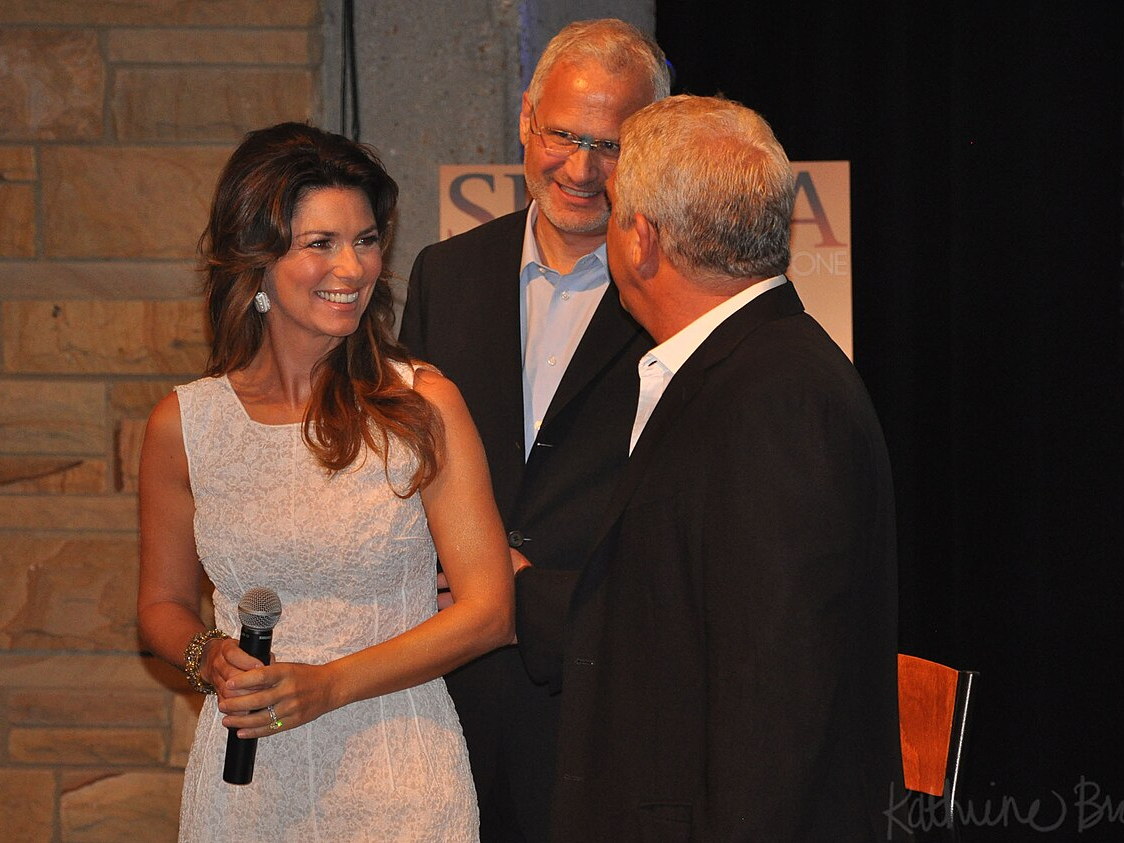 Shania Twain holding a microphone at an event in 2011
