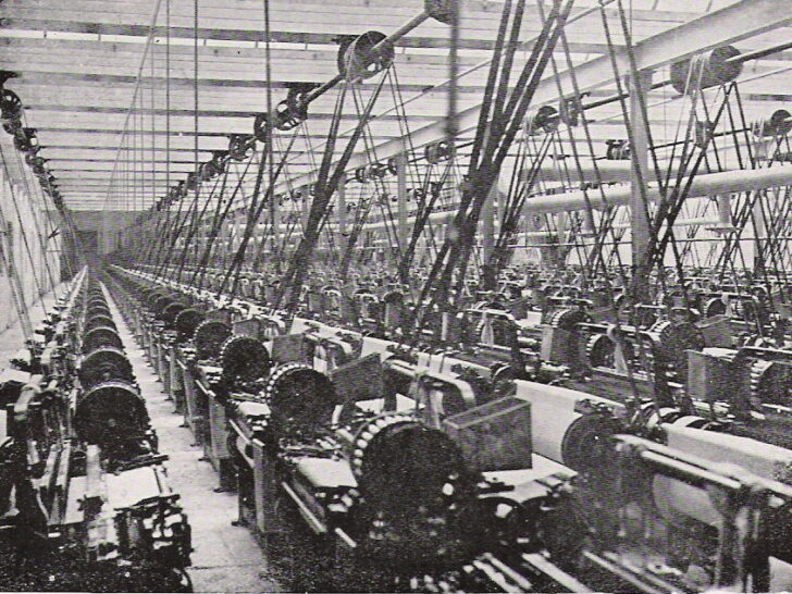 Rows of belt-driven weaving machinery inside a historic Lancashire cotton mill