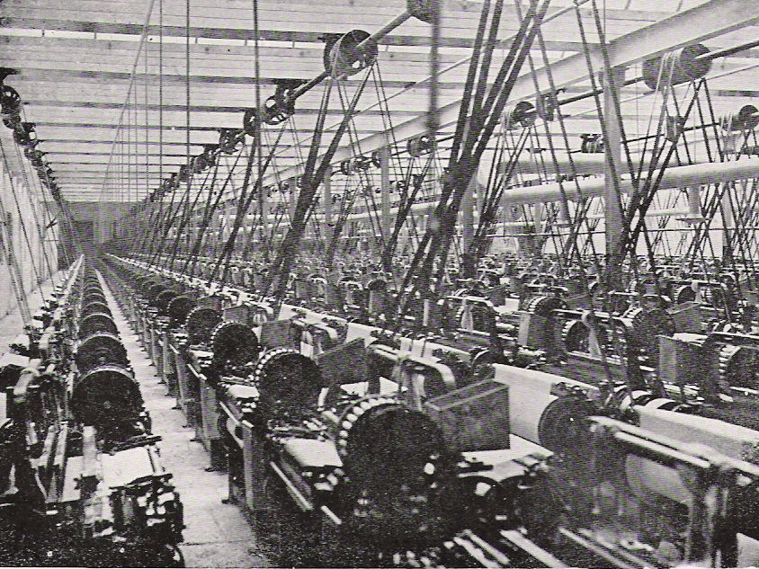 Rows of belt-driven weaving machinery inside a historic Lancashire cotton mill