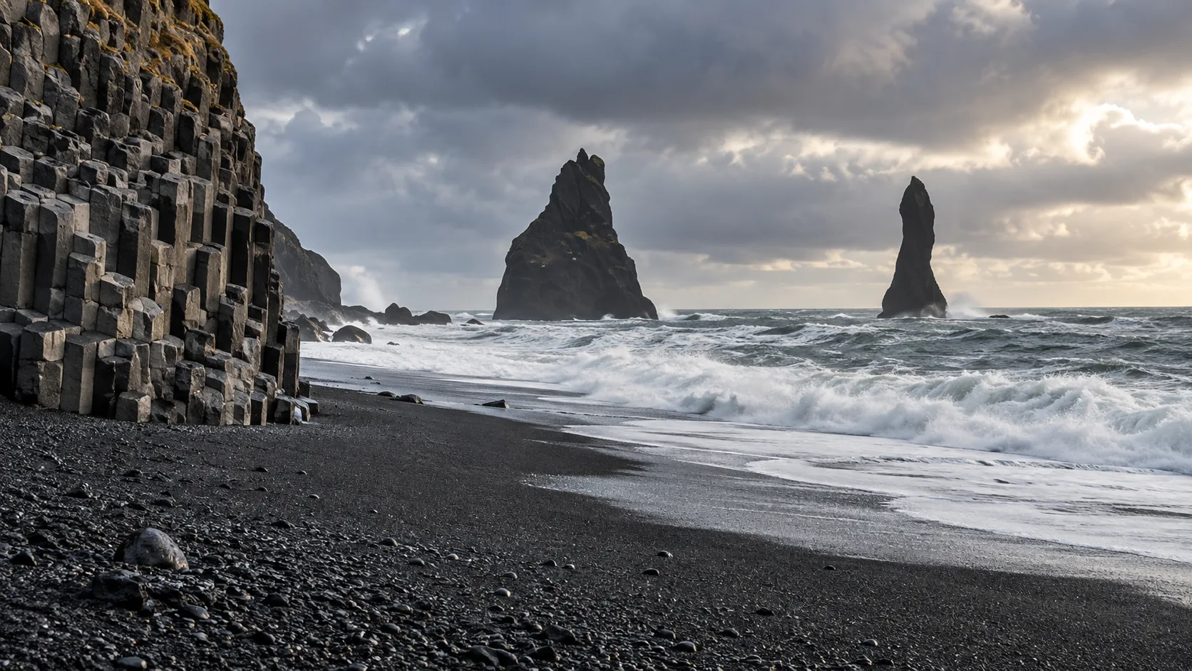 Basalt columns sea stacks and waves at Reynisfjara black-sand beach