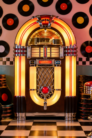Retro diner jukebox with colorful 45 rpm records and chrome stools