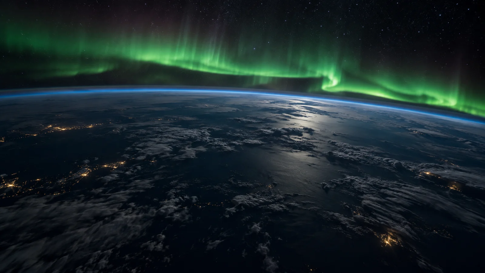 Green aurora glowing above Earth's thin blue atmosphere on the night side