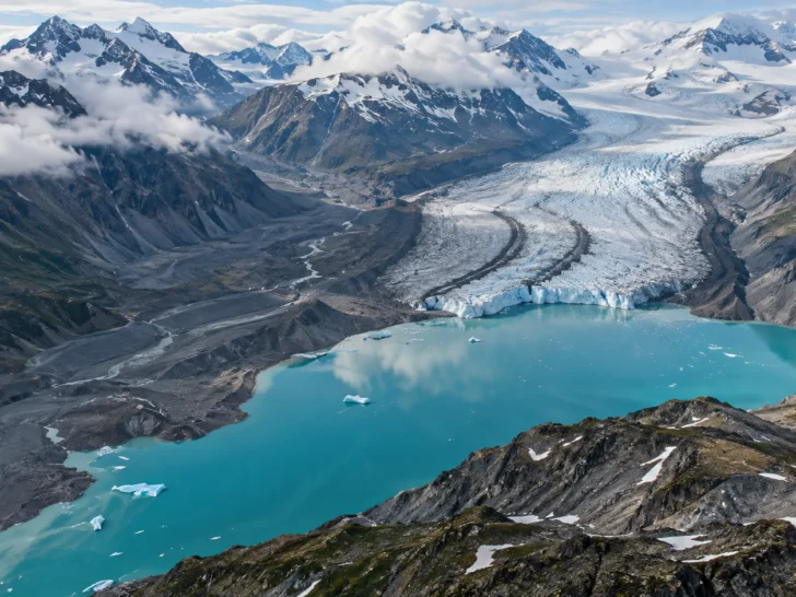 Retreating mountain glacier above a turquoise lake