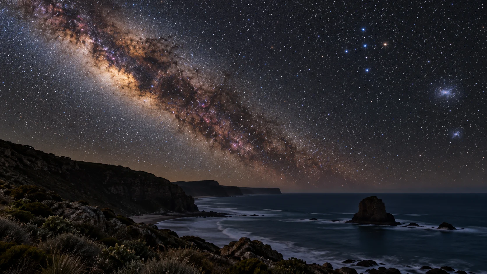 The Southern Cross rises beside the Milky Way over a dark coast