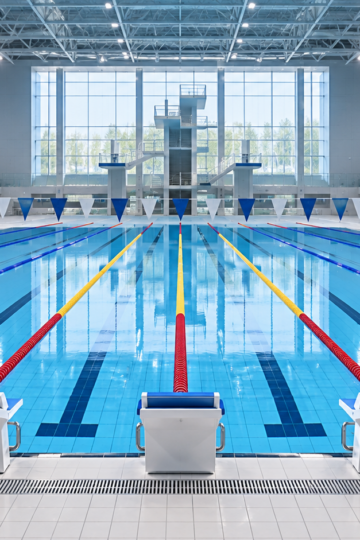 Empty Olympic-style swimming pool with ten lanes and blank starting blocks