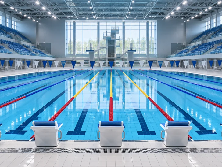Empty Olympic-style swimming pool with ten lanes and blank starting blocks
